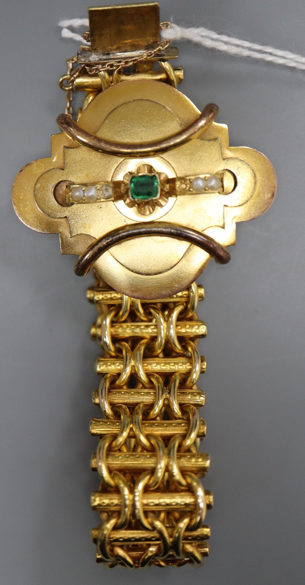 A Victorian yellow metal, emerald and seed pearl set bracelet, with cartouche shaped central motif, approx. 19cm, gross 38.5 grams.